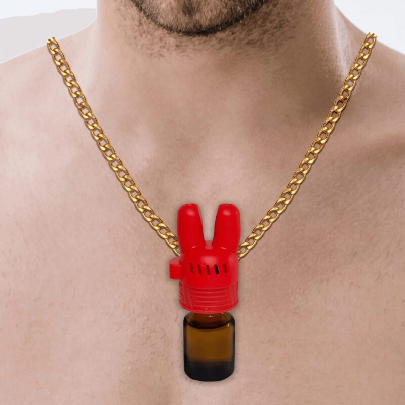 Close-up of a gold chain necklace worn around a neck, featuring a distinctive red bunny-ear shaped bottle topper attached to a small amber glass bottle. The topper appears to be made of plastic and has a whimsical character-like design with upright ears.