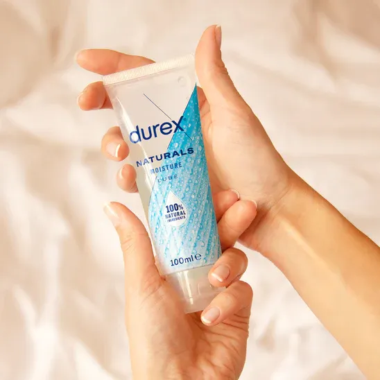 Dłoń trzymająca tubkę żelu intymnego na bazie wody Durex Naturals 100ml demonstrująca kompaktowy rozmiar i łatwe w użyciu opakowanie