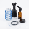 Titan Booster F106 Set – 100ml Glass Bottle, Flow Control & Leather Strap Titan Booster F106 Set complete kit with amber glass spray bottle, black applicator attachment, protective mesh sleeve, cap, tubing, and sealing accessories for precision liquid application